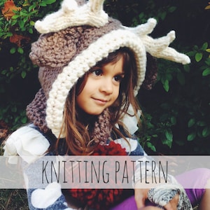 Op de afbeelding: Breipatroon voor een bruine en witte hertenkap met geweien. De muts wordt gedragen door een kind met bruin haar en bruine ogen. Het kind draagt een blauw-wit geblokt shirt en een rode pompon.