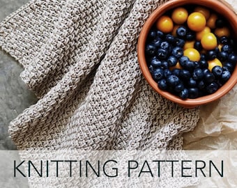 May include: A close-up of a knitted beige throw blanket with a bowl of blueberries and yellow plums on a brown paper background. The text "KNITTING PATTERN" is at the bottom of the image.