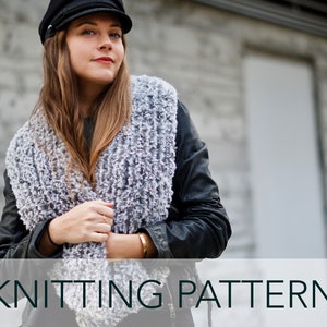 Può includere: Una donna indossa una sciarpa di lana grigia e bianca con una giacca di pelle nera e un cappello da baseball nero. Il testo "KNITTING PATTERN" è in basso nell'immagine.