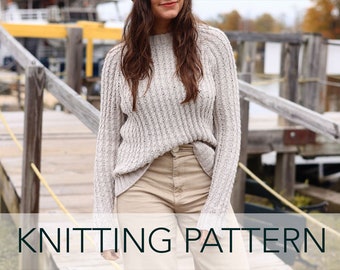 May include: A close-up of a woman wearing a light beige knitted sweater with a ribbed texture. The sweater has a round neckline and long sleeves. The woman is standing on a wooden dock with a yellow rope.
