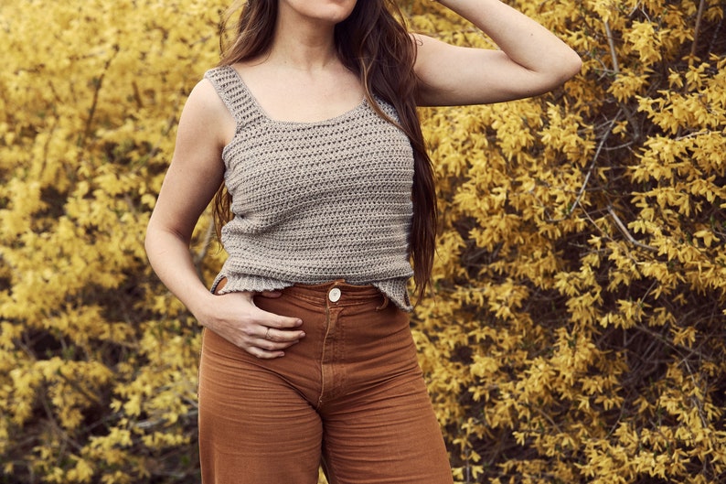 Peut inclure: Une femme portant un d&eacute;bardeur en crochet marron clair avec un pantalon taille haute marron.