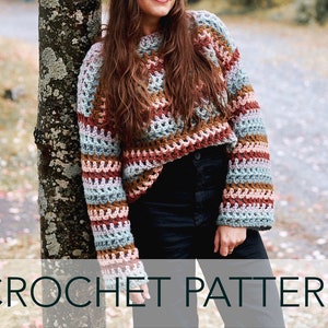 Pode incluir: Um suéter de crochê com um padrão listrado em tons de marrom, rosa, azul e verde. O suéter tem um caimento solto e mangas compridas. CROCHET PATTERN está escrito em branco sobre um fundo cinza.