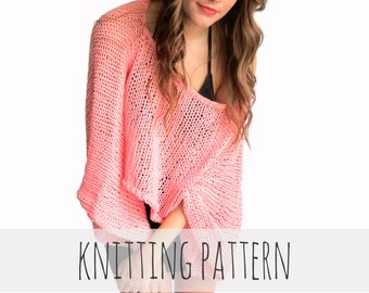 Può includere: Un maglione rosa lavorato a maglia con una trama larga e aperta. Il maglione ha una scollatura ampia e profonda e maniche lunghe. La modella indossa il maglione sopra un top nero senza maniche.
