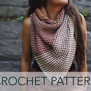 May include: A crochet shawl with a gradient of red, white, and brown colors. The shawl is triangular in shape and has a textured stitch pattern. CROCHET PATTERN is written in black text at the bottom of the image.
