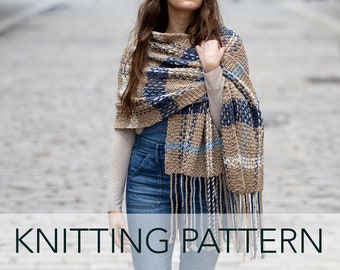 May include: A knitting pattern for a brown, blue and white plaid scarf with fringe. The scarf is being worn by a person with long brown hair.