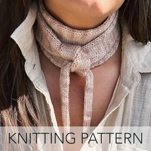 May include: A knitted scarf in shades of beige and pink, tied in a knot at the front. The scarf is worn around the neck, with the ends hanging down. The text "KNITTING PATTERN" is displayed at the bottom of the image.