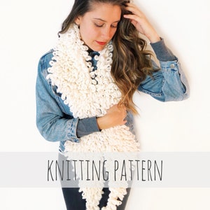 May include: A white chunky knit scarf with a loose, textured weave. The scarf is worn by a person with long brown hair and a denim jacket. The text "KNITTING PATTERN" is displayed below the scarf.