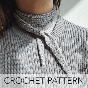 May include: A gray crochet neck warmer with a tied bow in the front.  The neck warmer is made with a chunky yarn and has a ribbed texture.  CROCHET PATTERN is written in black text at the bottom of the image.