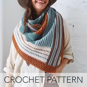 May include: A triangular crochet shawl featuring horizontal stripes in shades of teal, burnt orange, cream, and brown. The textile displays a variety of textured stitch patterns, including ribbed sections and openwork details, creating a layered appearance.