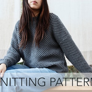 May include: A knitting pattern for a gray, textured sweater. The sweater is loose-fitting and has a round neckline.