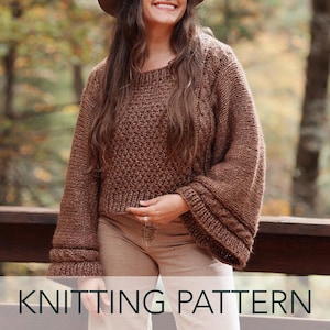 May include: A brown knitted sweater with a round neck and long sleeves. The sleeves have a cable knit design at the cuffs. The text "KNITTING PATTERN" is displayed at the bottom of the image. The sweater is made of a soft, textured yarn.