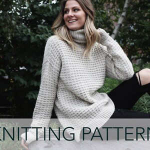 May include: A knitting pattern for a white turtleneck sweater with a textured stitch. The sweater is shown being worn by a person sitting on a bench.