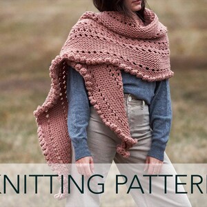 May include: A pink knitted shawl with a lacy pattern and bobbles along the edges.  KNITTING PATTERN.