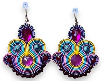 May include: A pair of colorful earrings with a multi-layered design. The earrings are made of a variety of colors, including pink, yellow, blue, and green. The earrings are adorned with small, sparkling crystals.