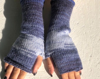 Könnte beinhalten: Ein Paar blaue und weiße fingerlose Strickhandschuhe mit einem weißen Streifen.