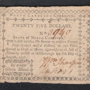 May include: A vintage North Carolina currency note for twenty-five dollars, dated August 8, 1778. The aged paper bill features ornate text and decorative borders, with the text "Death to Counterfeit" and "Sic transit Gloria Mundi".