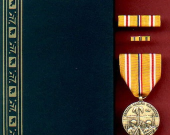 May include: A gold medal with a ribbon and a box. The medal features a design of soldiers in a jungle setting with the text "Asiatic-Pacific Campaign". The ribbon is yellow with red and blue stripes. The box is green with gold trim and the text "United States of America".