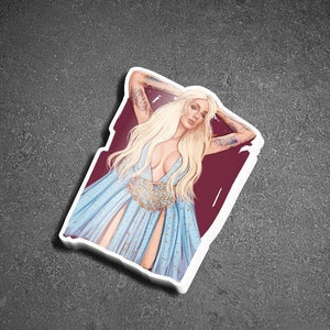 May include: A sticker featuring a woman with long blonde hair wearing a blue gown with gold accents. She is lying down with her arms raised above her head. The background is a dark red colour.