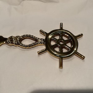 Abrecartas de latón con forma de timón náutico. Accesorio de escritorio de latón.