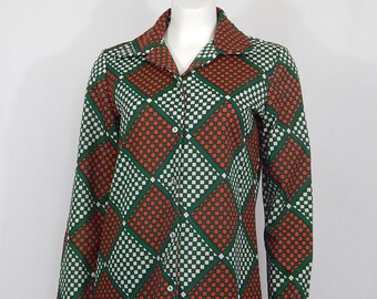 May include: A long-sleeved button-up shirt with a checkered pattern in shades of green, white, and orange. The shirt has a collared neckline and a button-up front.