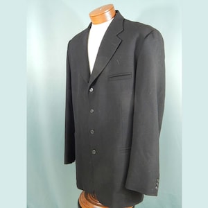 May include: A black blazer with a four-button closure and a single flap pocket on the left side.