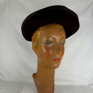 Könnte beinhalten: Ein brauner Filzhut mit breiter Krempe. Der Hut sitzt auf einem Mannequin-Kopf.