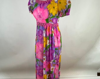 Peut inclure: Une longue robe maxi violette à imprimé floral avec des fleurs roses, jaunes et blanches. La robe a une bordure en crochet au niveau du col et de la taille.