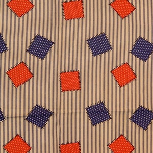 May include: A beige fabric with a striped pattern featuring red and blue diamond shapes. The diamonds have a dotted pattern and are sewn on with a contrasting thread.