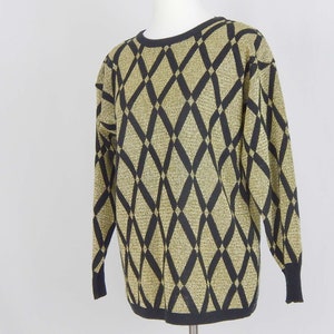 May include: A gold and black sweater with a diamond pattern. The sweater is made of a soft, knit fabric.