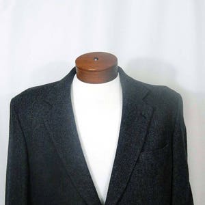 May include: A dark gray herringbone blazer with a single button closure.