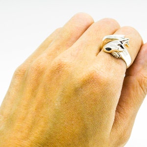 May include: A silver ring featuring a detailed frog design. The frog is curled up with its legs crossed and its eyes closed.
