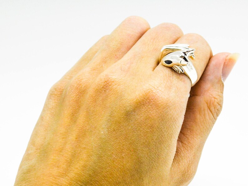 May include: A silver ring featuring a detailed frog design. The frog is curled up with its legs crossed and its eyes closed.