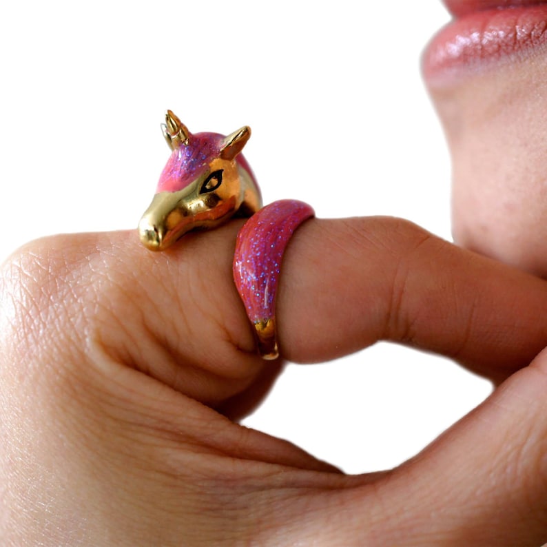 May include: A pink and gold unicorn ring with a sparkly finish. The ring is adjustable and fits most finger sizes.
