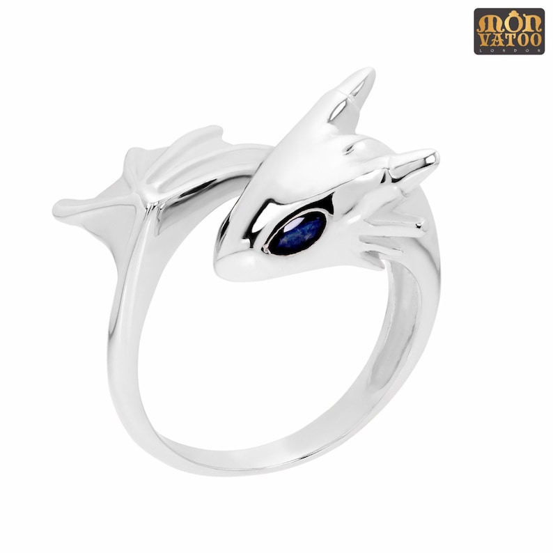 May include: Silver ring with a dragon design and a blue gemstone eye.