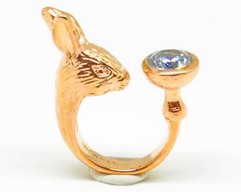 May include: A gold-toned ring featuring a rabbit head design with a clear gemstone on the top.