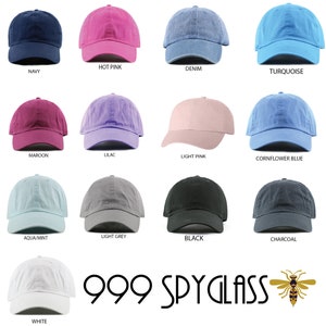 K&ouml;nnte beinhalten: Eine Sammlung von 12 leeren Baseballkappen in verschiedenen Farben, darunter Marineblau, Pink, Denim, T&uuml;rkis, Rotbraun, Lila, Hellrosa, Kornblumenblau, Aqua/Mint, Hellgrau, Schwarz, Anthrazit und Wei&szlig;. Die Kappen sind in einem Raster angeordnet, mit dem Markennamen "999 SPYGLASS" und einem Bienenlogo am unteren Rand.