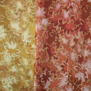 Pu&ograve; includere: Due campioni di tessuto con un motivo floreale. Il campione a sinistra &egrave; di colore marrone chiaro con un motivo floreale bianco. Il campione a destra &egrave; di colore rosso scuro con un motivo floreale bianco.