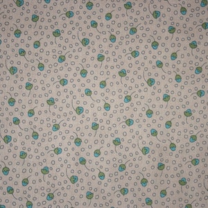 Peut inclure: Un tissu beige avec un motif répétitif de petites fleurs bleues et vertes. Les fleurs sont dessinées à la main, avec un style simple et sont soulignées de noir.