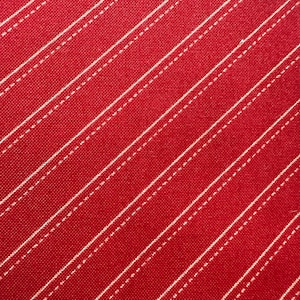 Könnte beinhalten: Roter Stoff mit weißen diagonalen Streifen. Der Stoff hat eine subtile Textur.