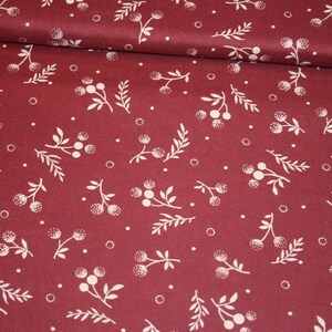 May include: Red fabric with a white floral pattern. The pattern features small sprigs with white berries and leaves.