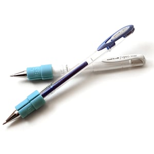 Könnte beinhalten: Zwei blaue und weiße Gel-Stifte mit einem blauen und weißen Griff. Die Stifte sind mit "Uni-ball Signo Broad" beschriftet.