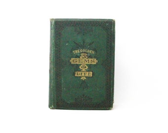 May include: A vintage hardback book with a dark green cloth cover featuring black embossed decorative borders and gold lettering on the front that reads THE GOLDEN GEMS OF LIFE, with a small crown icon above the word GEMS and floral accents.