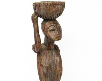 頭に籠を乗せた女性のアフリカの木彫像。東アフリカ美術の彫像。伝統的な手彫りの置物。力強さ。