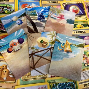 May include: A collection of ten Pokemon trading cards featuring various Pokemon characters and trainers. The cards are painted with watercolor and feature beach scenes.