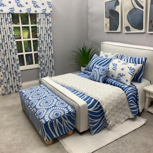 Può includere: Un set da camera in miniatura con motivi floreali e a righe blu e bianchi. Il set comprende un letto con cuscini, una panca, tende e opere d'arte. La combinazione di colori è un mix di bianco e blu, creando un'estetica rilassante.