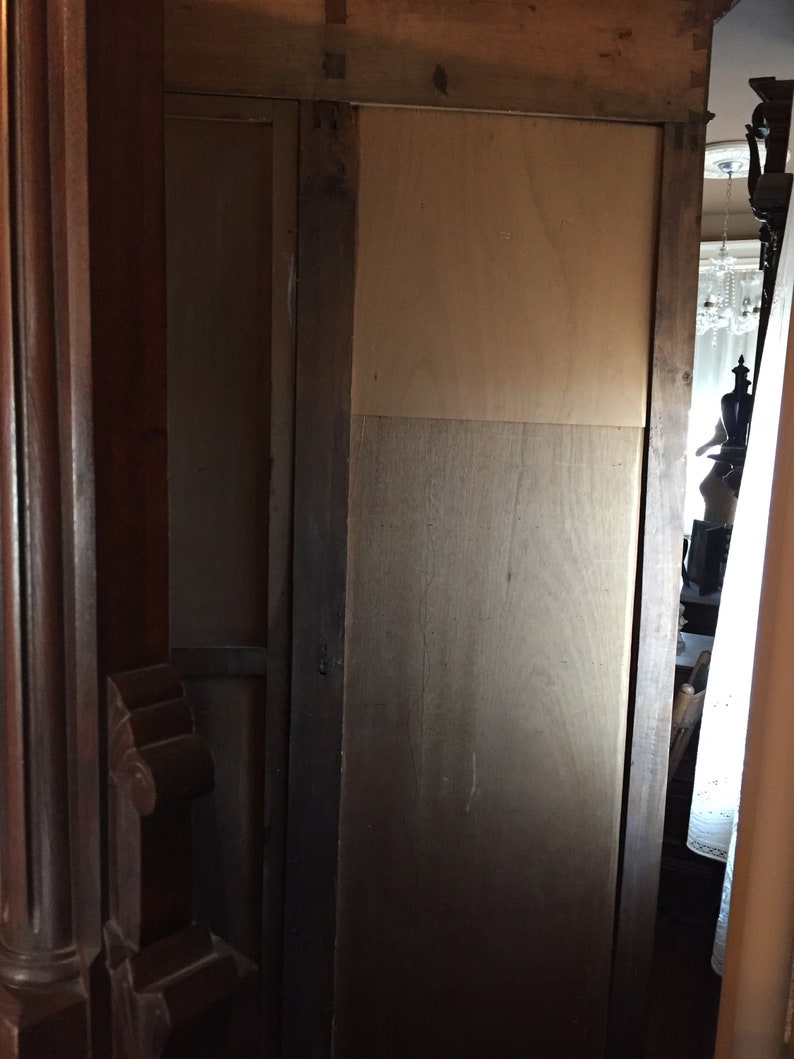 May include: A wooden cabinet with a dark brown finish and a single door. The door is closed and has a simple design. The cabinet is made of wood and has a traditional style.