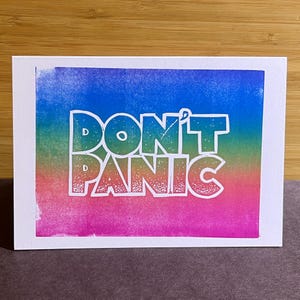 Tarjeta de felicitación en linograbado con la Guía del autoestopista Don't Panic
