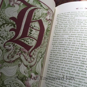 Photo showing the inside of The Neverending Stoy book, red and green illustration/illustrated letter at the beginning of each chapter, and red and green text throughout the book