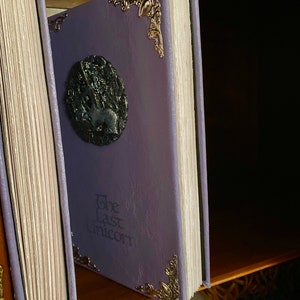 Photo shows two copies of The Last Unicorn book, details of the deckled edge pages