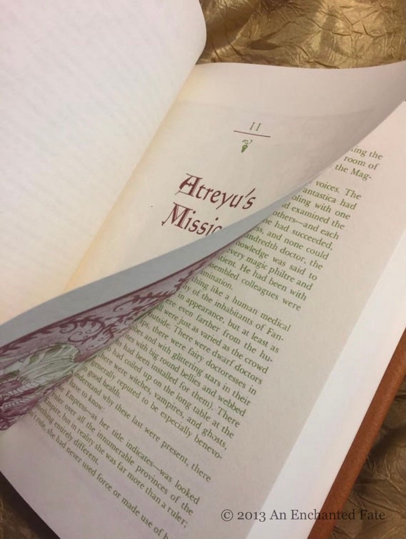 Photo showing the inside of The Neverending Story book, flipping through the pages, showing the red and green text, and how the chapter begins with an illustrated letter/